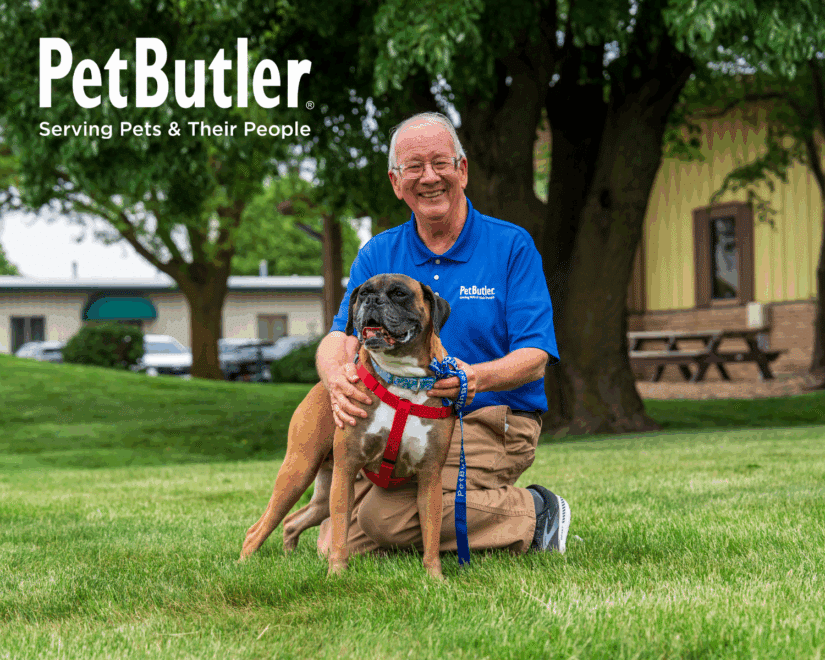 Pet Butler pet care professional smiling while posing with a dog.