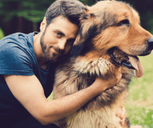 man hugging large fluffy dog